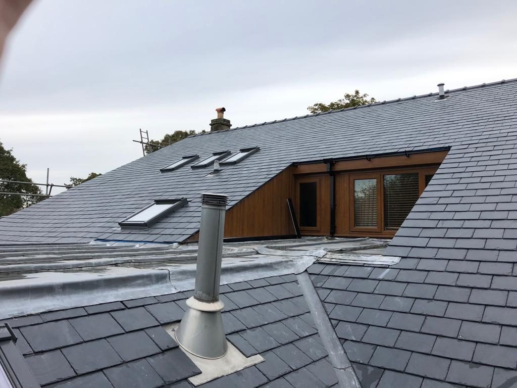Multi-level slate roof with roof windows, a timber dormer and lead flashings
