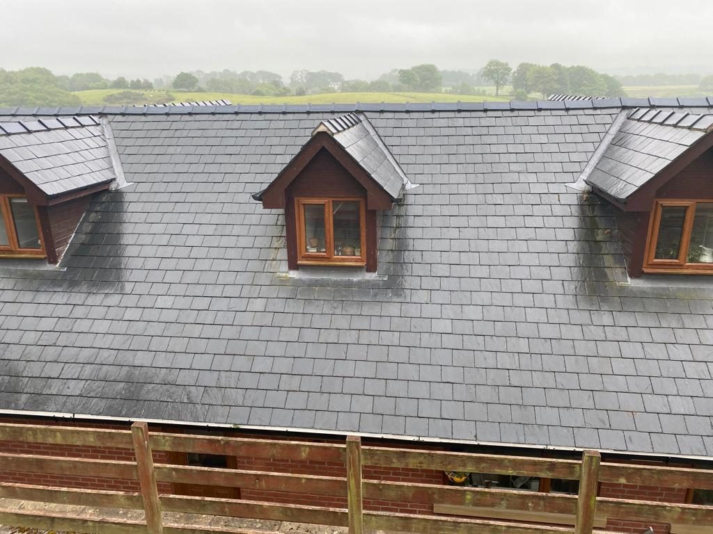 Large grey slate roof with three timber-cheeked dormers and lead valleys