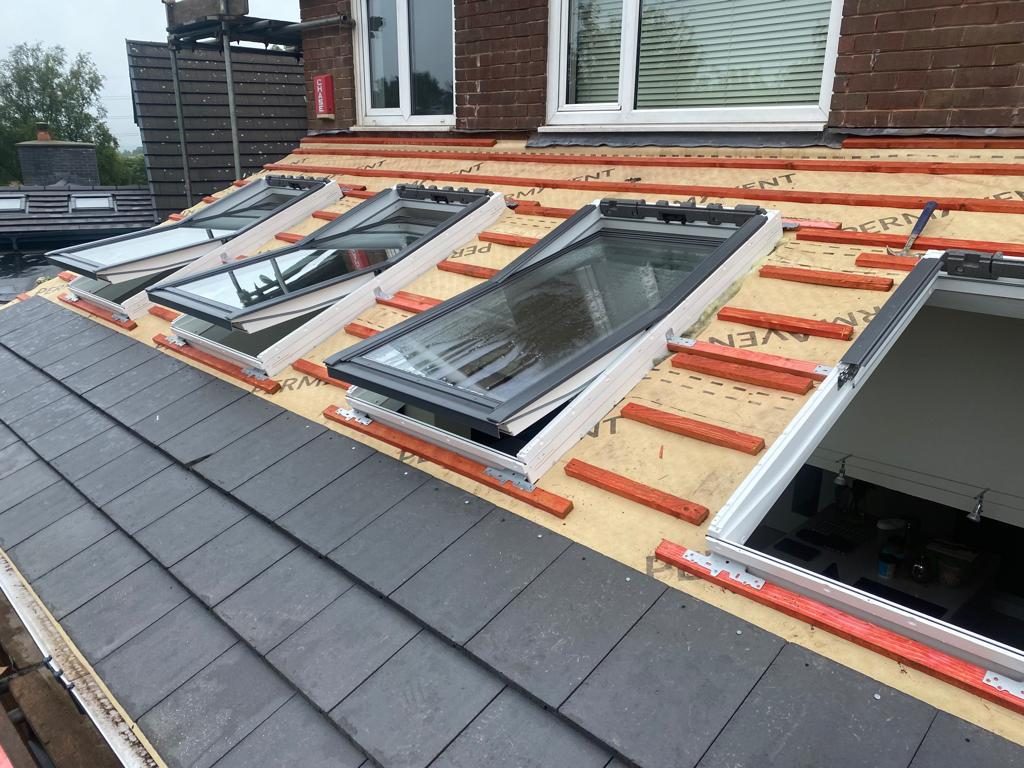 Four roof windows set into a tiled pitch with red battens and Permavent underlay